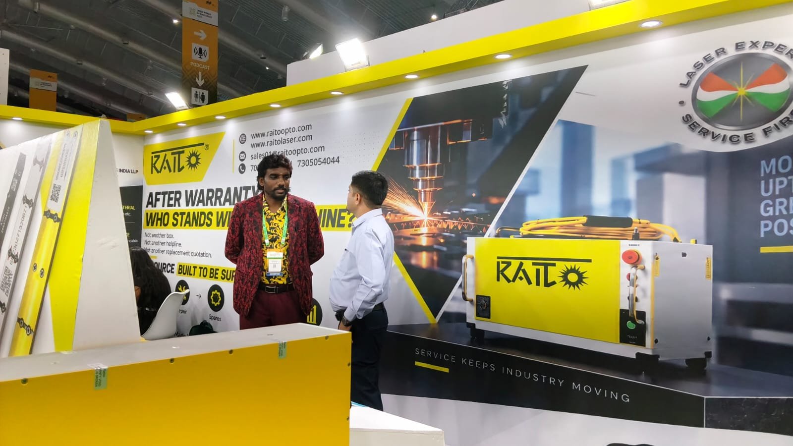 RAITO engineer speaking with a visitor at the stand — BIEC Bengaluru